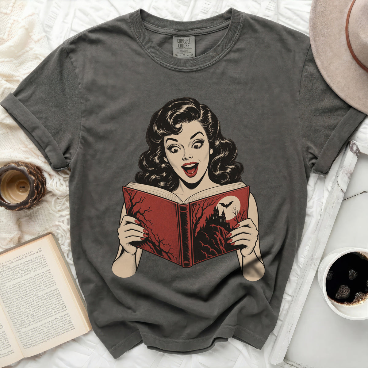 Dark gray t-shirt with vintage surprised woman reading a spooky book graphic.