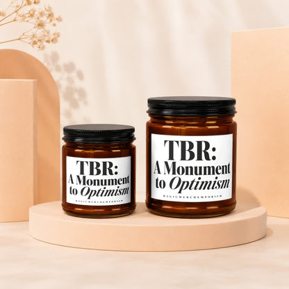Two amber glass candles with black lids; one larger than the other.