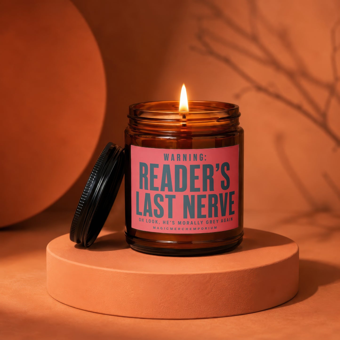 Amber jar candle with a lit flame and a pink label reading "Reader's Last Nerve."