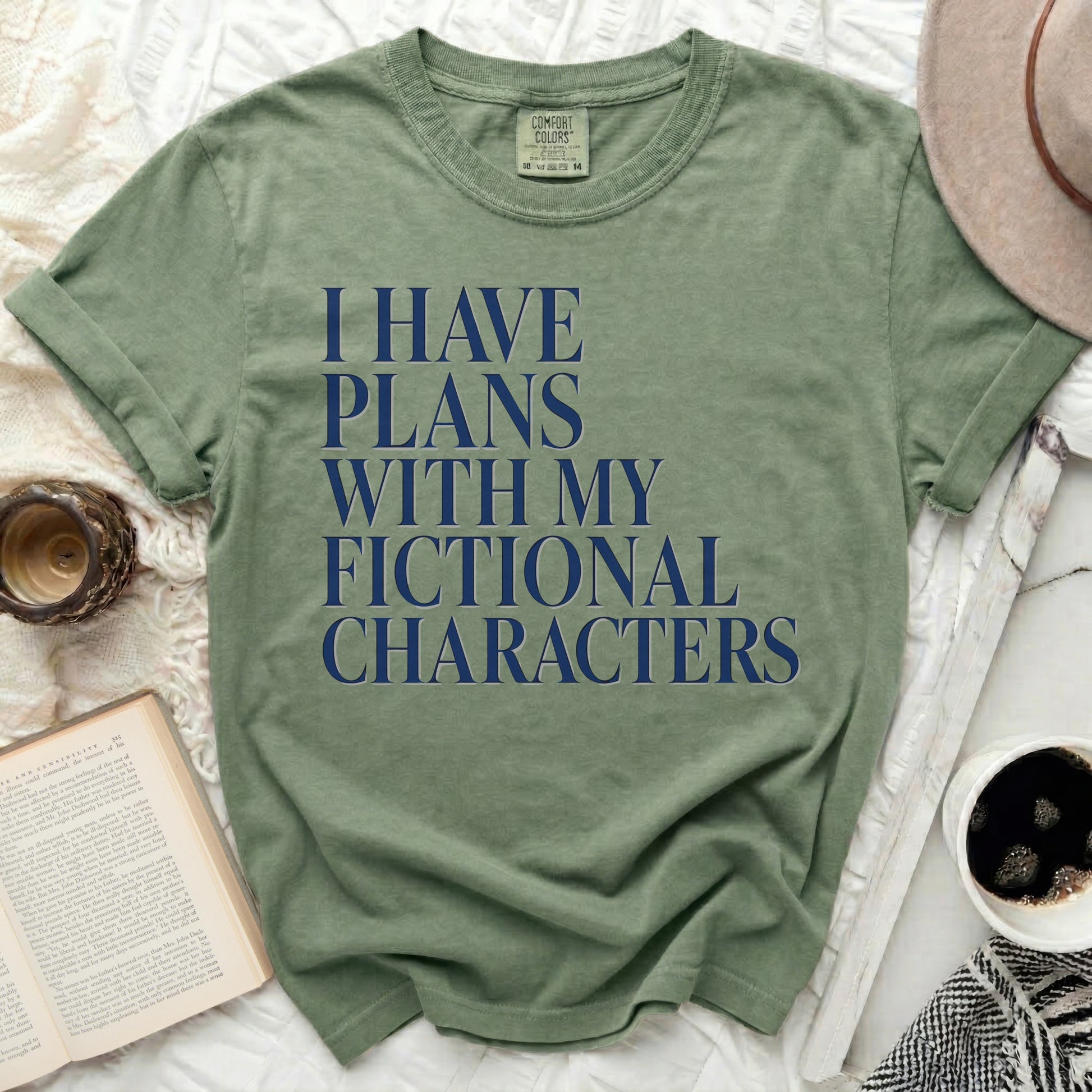 Green t-shirt with navy blue text reading "I HAVE PLANS WITH MY FICTIONAL CHARACTERS".