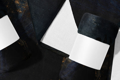 Dark abstract pattern on folded fabric with white insert.