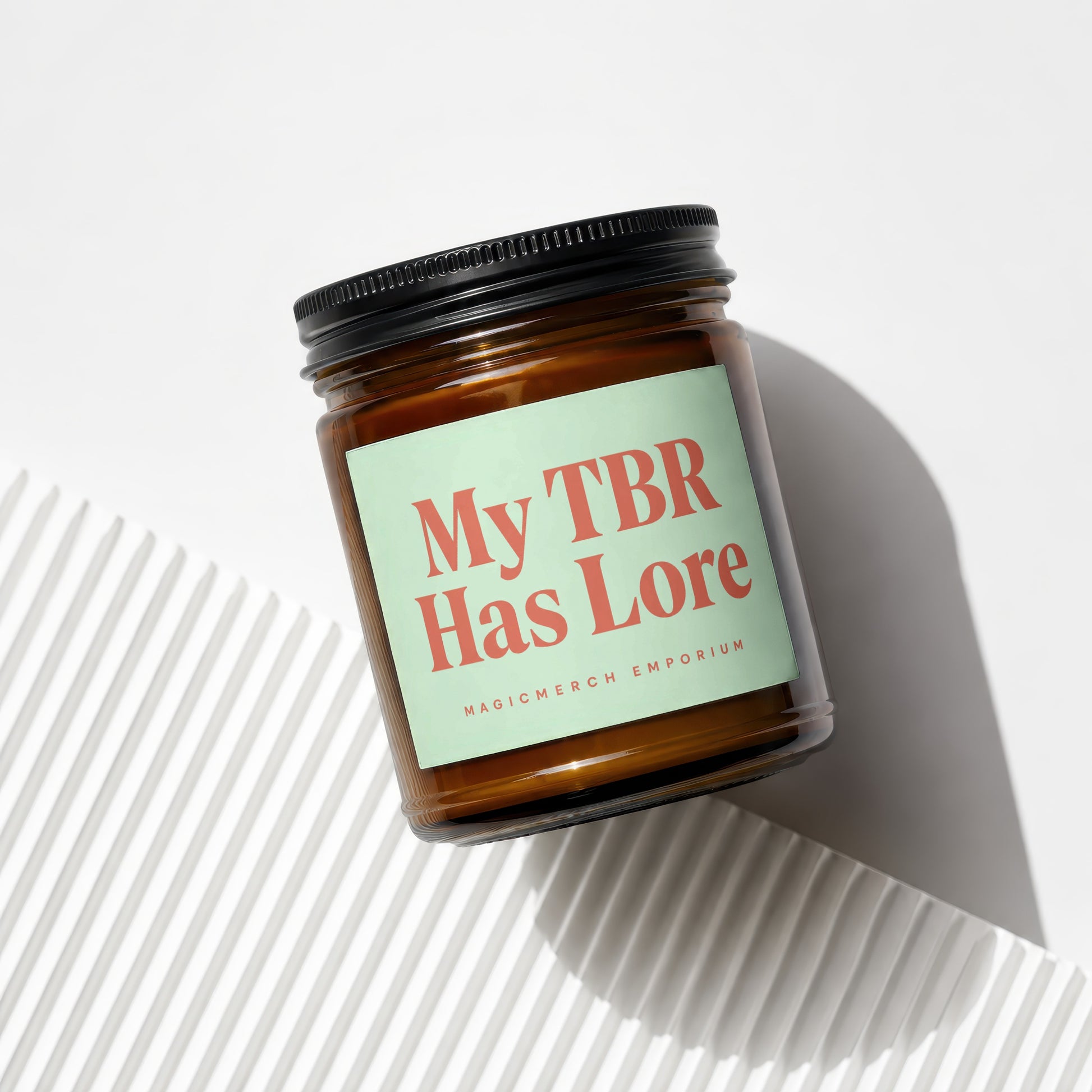 Amber jar candle with label reading "My TBR Has Lore" and "MAGICMERCH EMPORIUM".