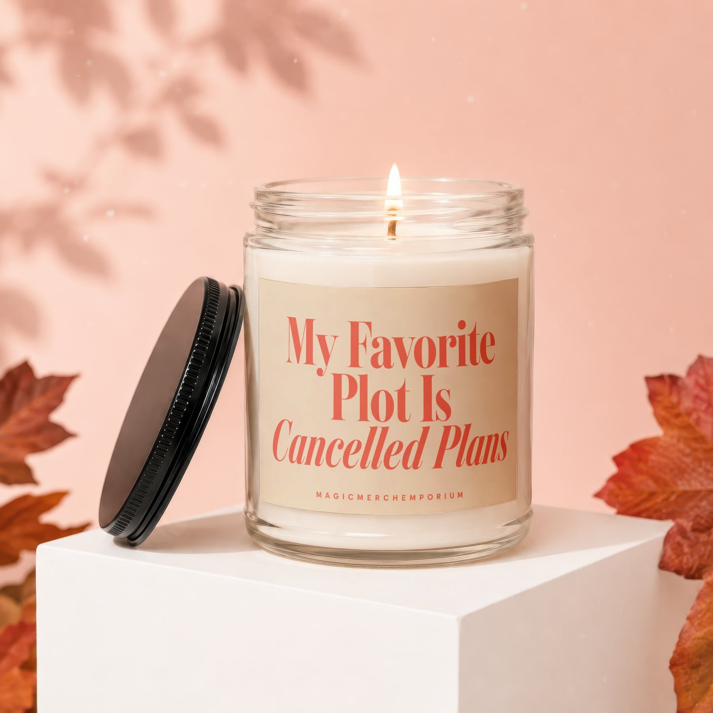 Candle with text "My Favorite Plot Is Cancelled Plans" and "MagicMerch Emporium."