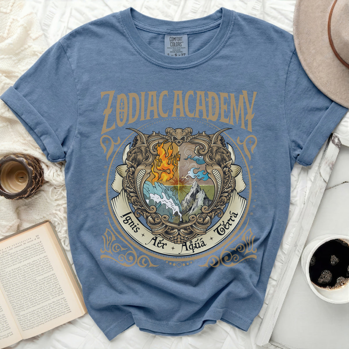 A blue Zodiac Academy graphic t-shirt with a vintage crest depicting fire, water, air, and earth elements.