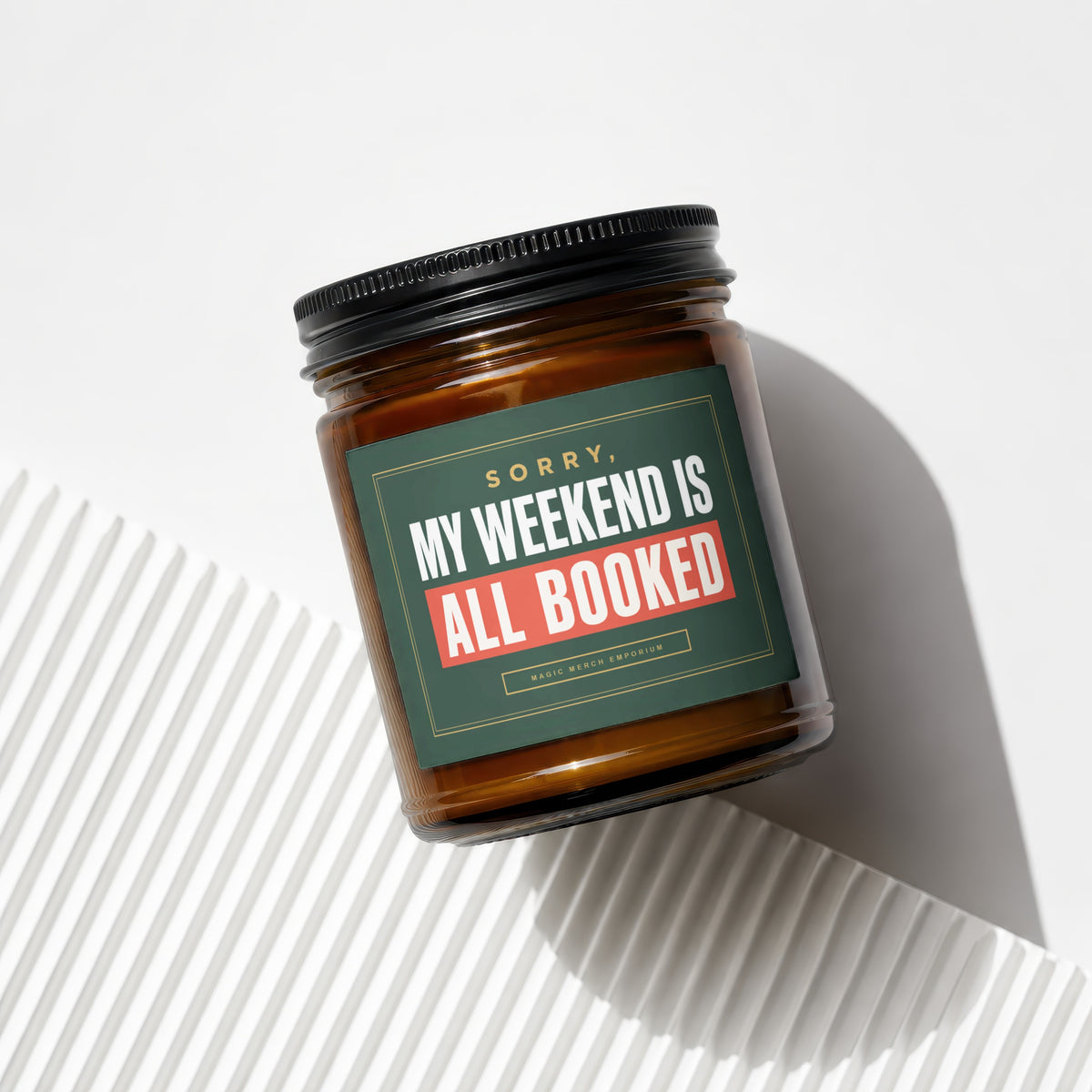 Amber jar candle with a green label that reads "Sorry, My Weekend Is All Booked."