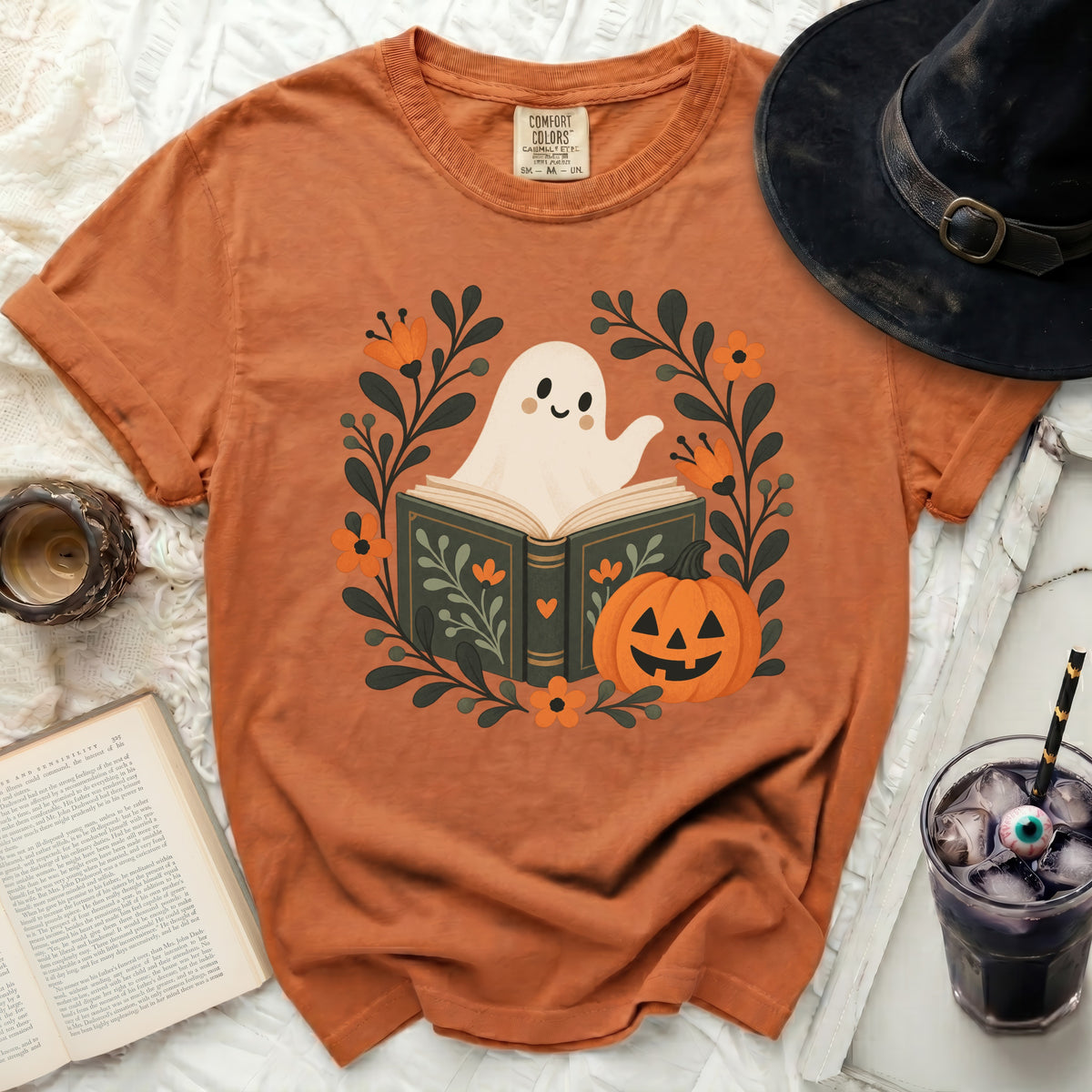 Orange t-shirt with a ghost reading a book and a pumpkin design.