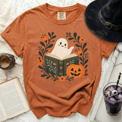 Orange t-shirt with a ghost reading a book and a pumpkin design.