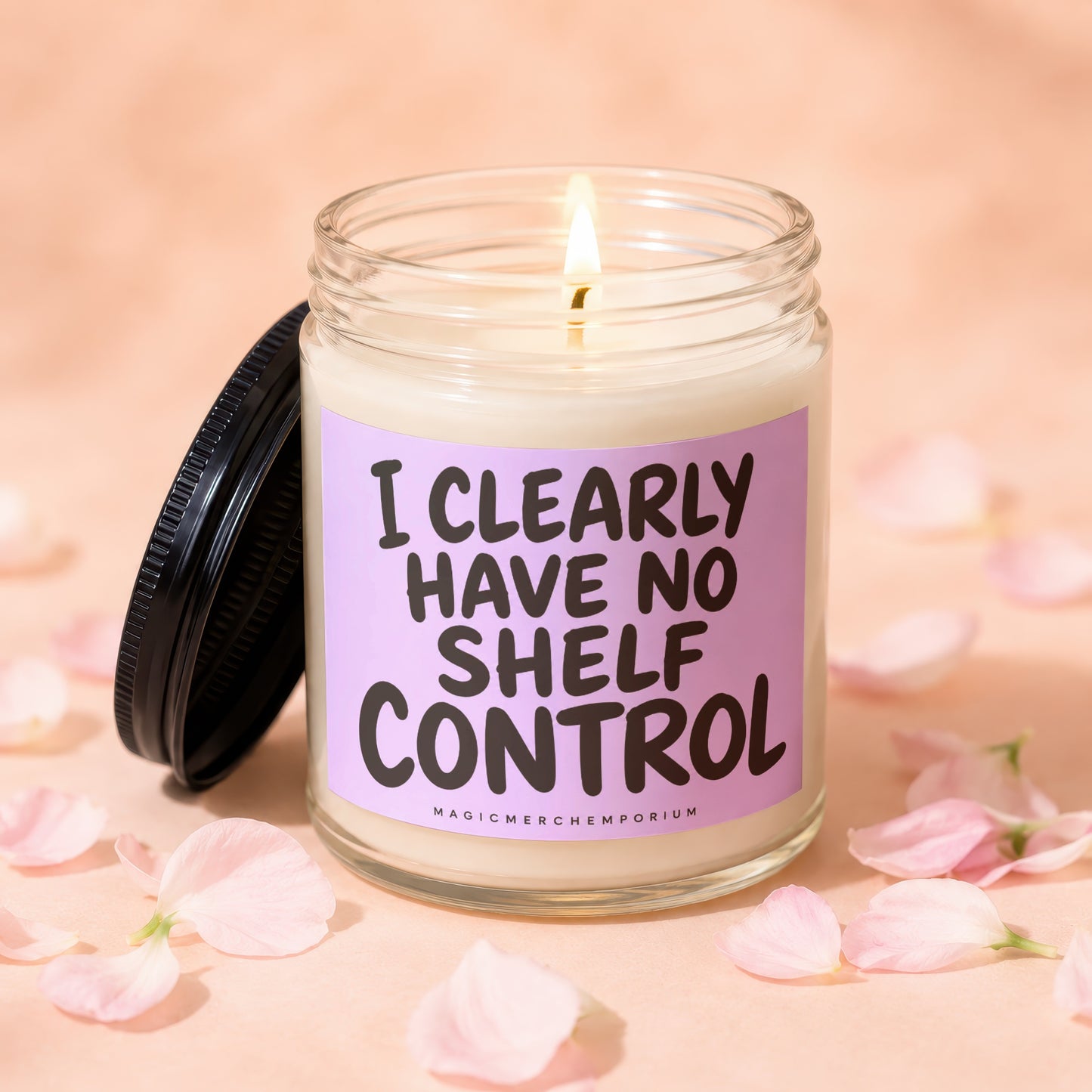 Glass jar candle with lit wick and black lid, saying "I CLEARLY HAVE NO SHELF CONTROL".