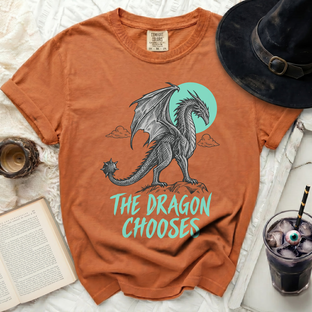 Orange t-shirt with a black dragon graphic and the text "THE DRAGON CHOOSES".