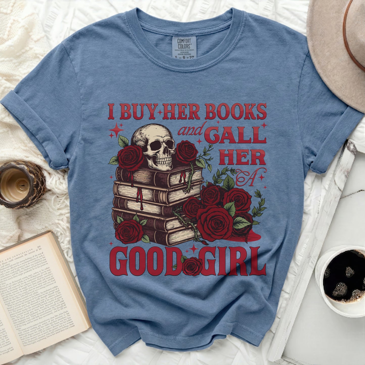 Blue t-shirt with skull, books, roses, and text "I BUY HER BOOKS and GALL HER A GOOD GIRL".