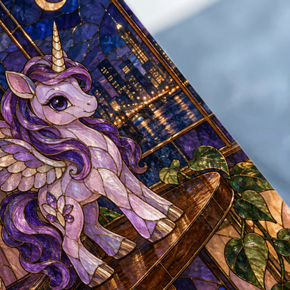 Stained glass unicorn with wings on a wooden surface, against a city skyline at night.