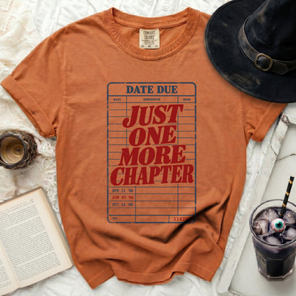 Orange t-shirt with "DATE DUE JUST ONE MORE CHAPTER" library card design.