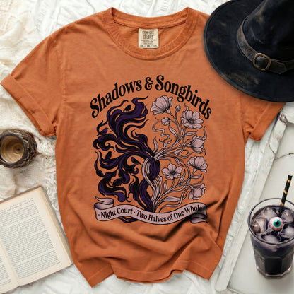 Orange t-shirt with "Shadows & Songbirds" text and intricate design.