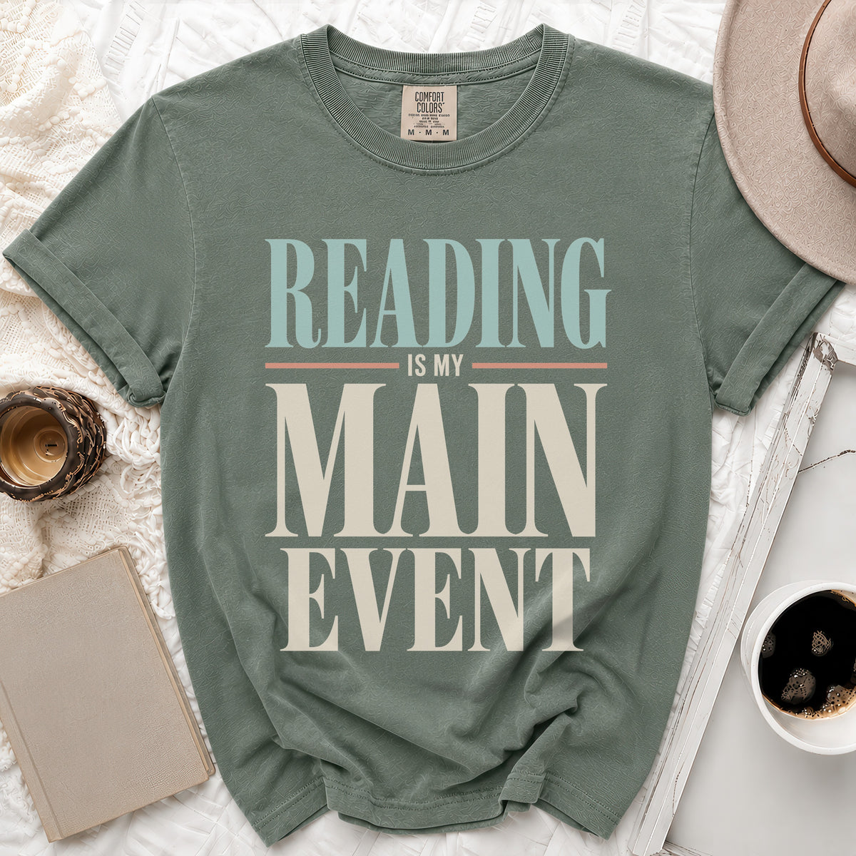 Green t-shirt with "Reading is My Main Event" text in blue, pink, and tan.