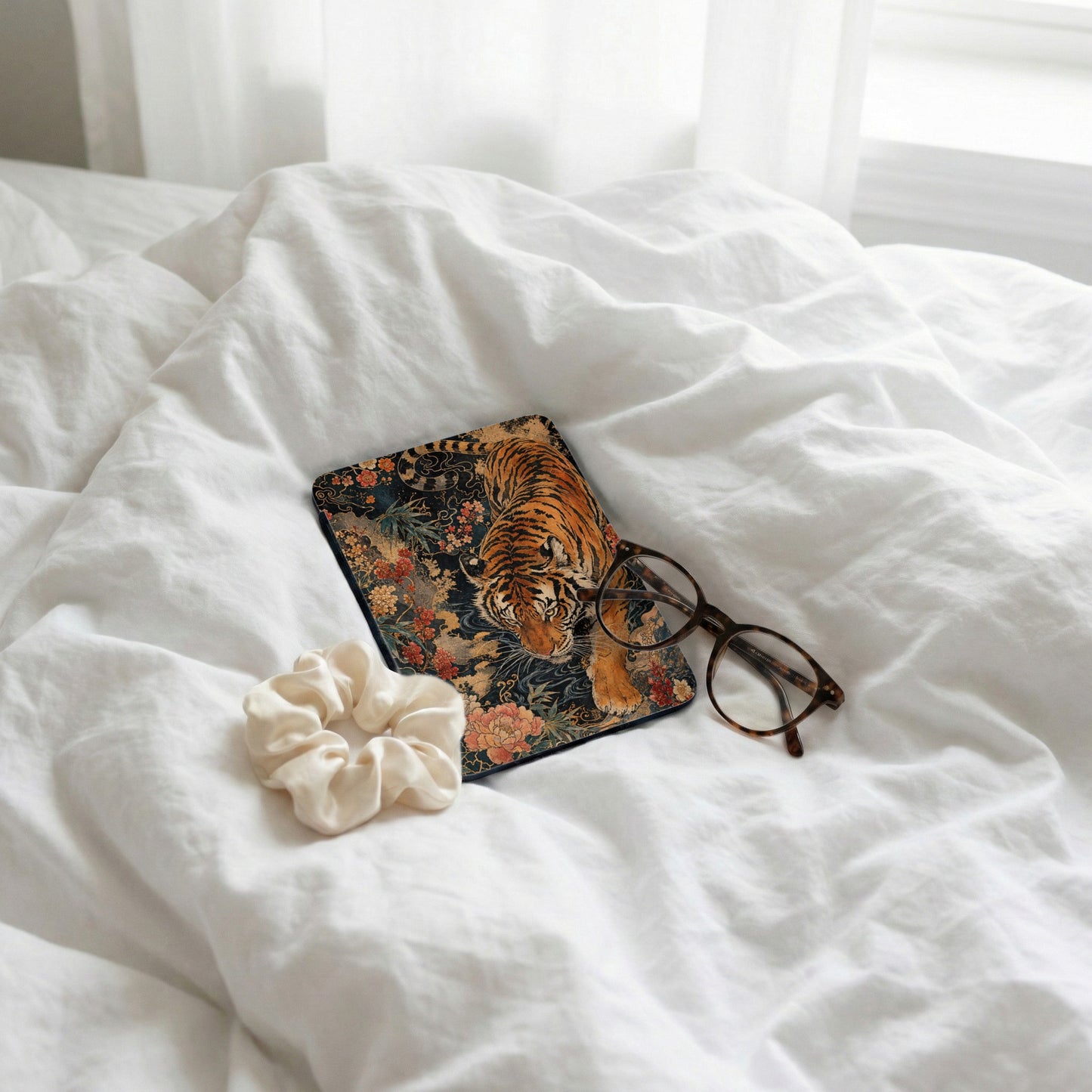 Mousepad with tiger and floral design next to glasses and scrunchie.