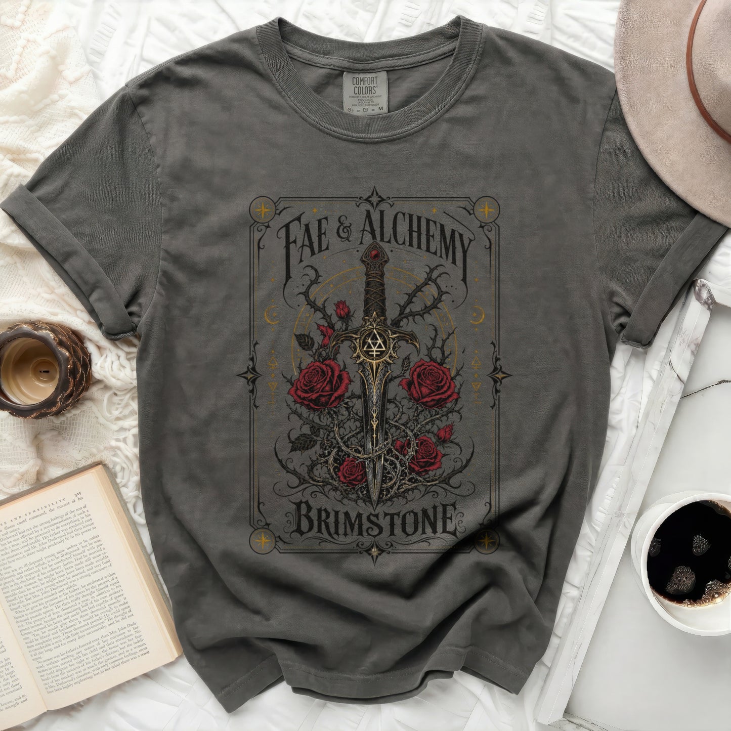Dark grey t-shirt with a sword and roses design, text "Fae & Alchemy Brimstone".