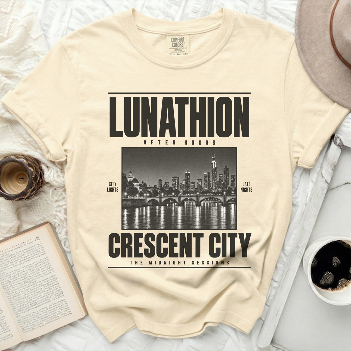 Cream t-shirt with black text "LUNATHION AFTER HOURS" and "CRESCENT CITY THE MIDNIGHT SESSIONS" over a cityscape.