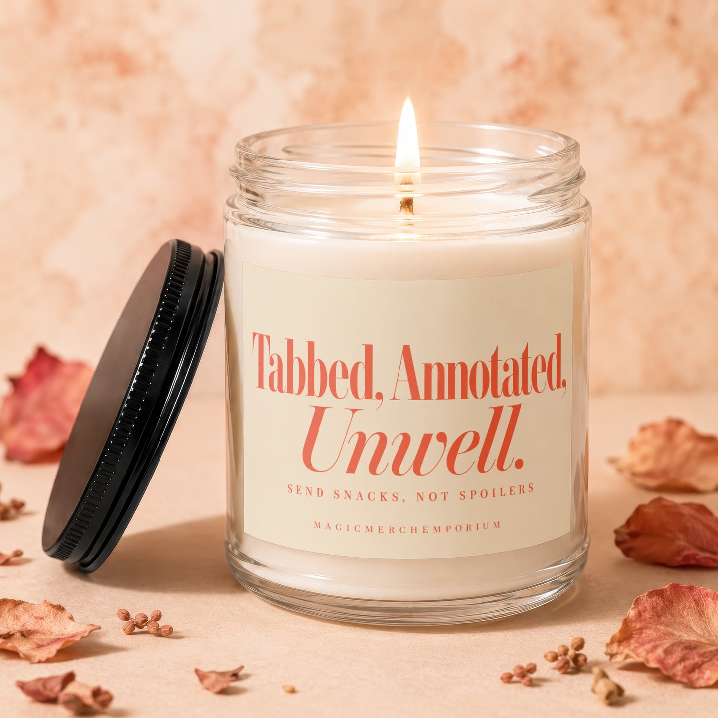 Candle with text "Tabbed, Annotated, Unwell. Send Snacks, Not Spoilers."