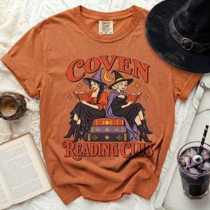 Orange t-shirt with "Coven Reading Club" graphic of witches reading books.