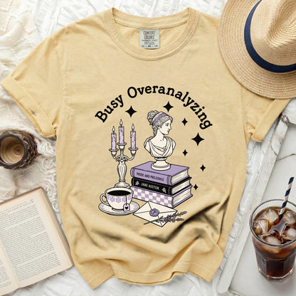 Yellow Comfort Colors t-shirt with "Busy Overanalyzing" and literary graphics.