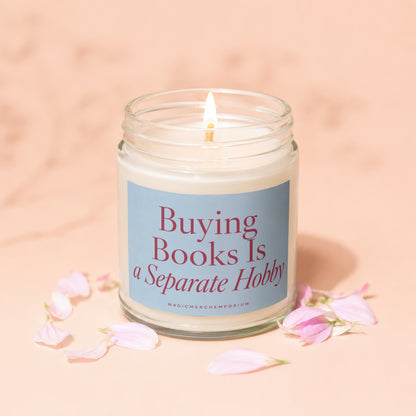 Jar candle with lit wick and "Buying Books Is A Separate Hobby" text.