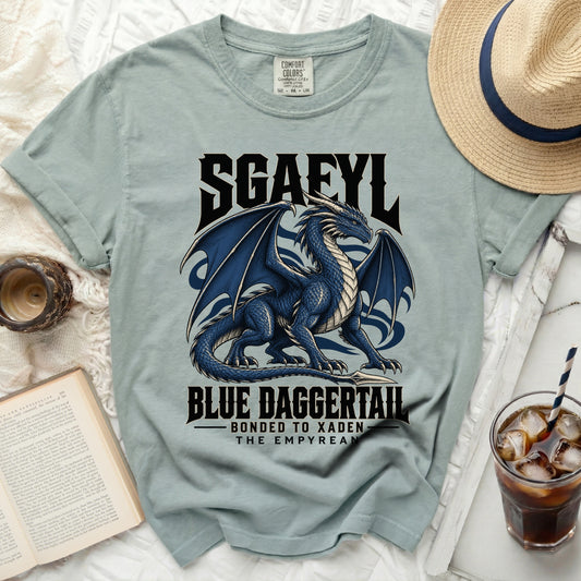 Light blue t-shirt with a blue dragon graphic and text "SGAFYL", "BLUE DAGGERTAIL", "BONDED TO XADEN", "THE EMPYREAN".