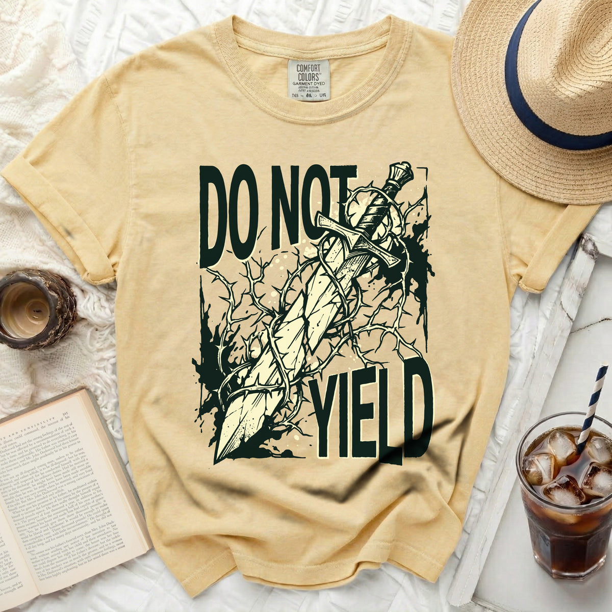 "Do Not Yield" graphic with sword and thorns on a yellow t-shirt.