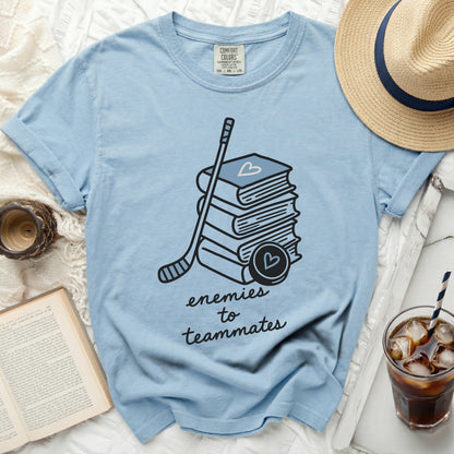 Light blue t-shirt with hockey stick, puck, and books design and text.