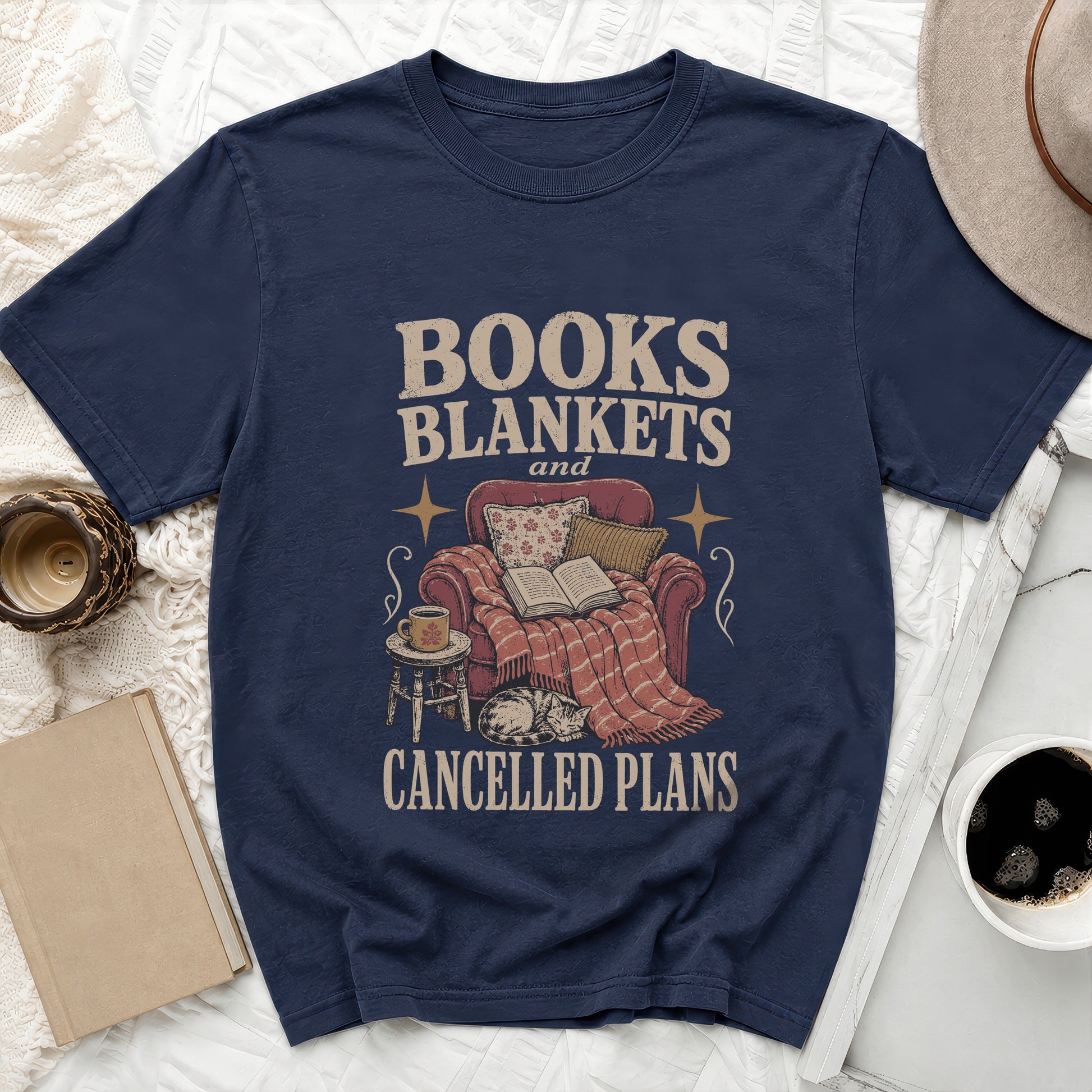 Navy t-shirt with "Books Blankets and Cancelled Plans" text and cozy scene.