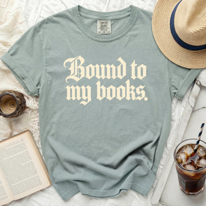 Dusty blue t-shirt with "Bound to my books." graphic print.