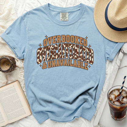 Light blue t-shirt with "Overbooked Overcaffeinated & Unavailable" text.