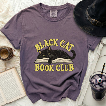 Purple t-shirt with black cat on open book graphic and "BLACK CAT BOOK CLUB" text.