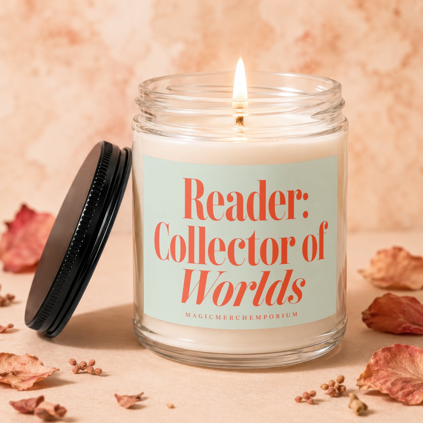 Glass candle with lit flame and label that reads "Reader: Collector of Worlds"