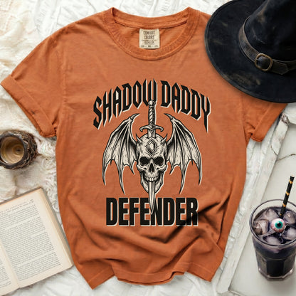 Orange t-shirt with skull, wings, sword, and "Shadow Daddy Defender" text.