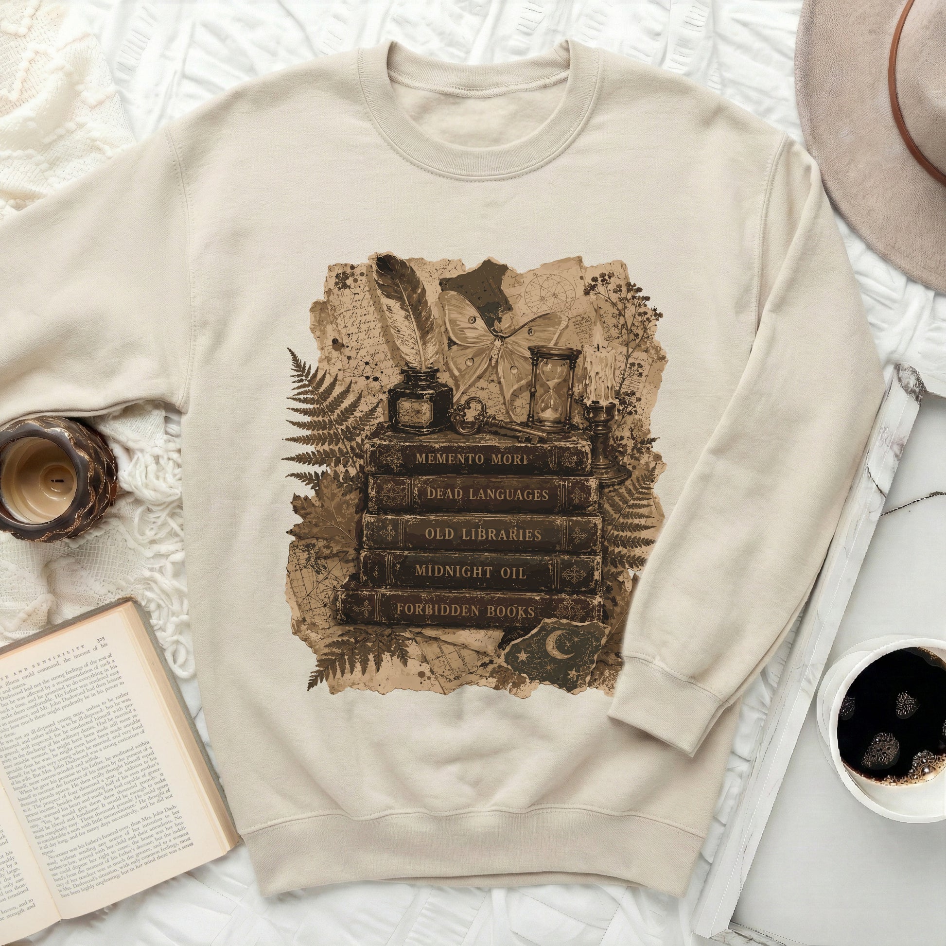 Cream sweatshirt with a vintage collage graphic of books, moth, inkwell, and hourglass.