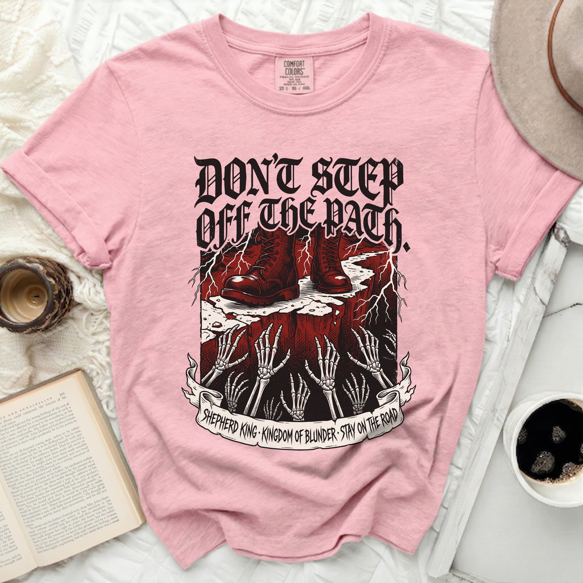 Pink t-shirt with "Don't Step Off the Path" graphic and skeleton hands.