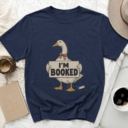 Navy t-shirt with a goose graphic holding an "I'M BOOKED" sign and a book.