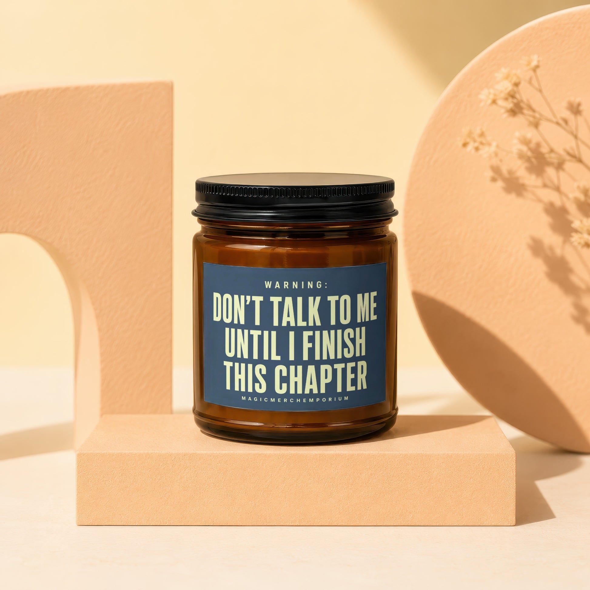 Brown glass candle with dark blue label reading "Don't talk to me until I finish this chapter."