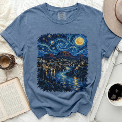 Blue t-shirt with a starry night landscape print inspired by Van Gogh.