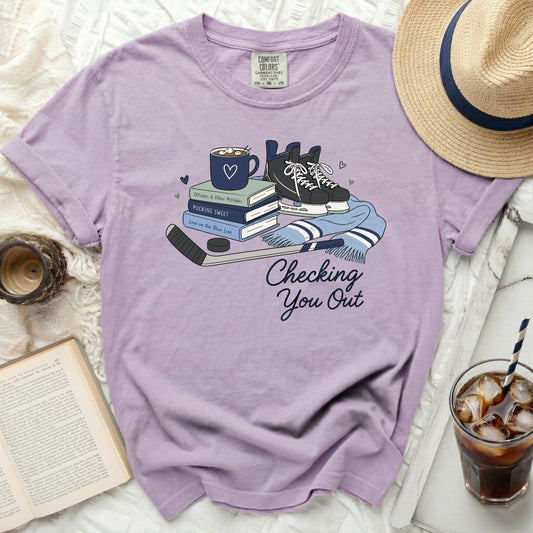 Purple comfort colors t-shirt with hockey skates, books, and mug graphic.