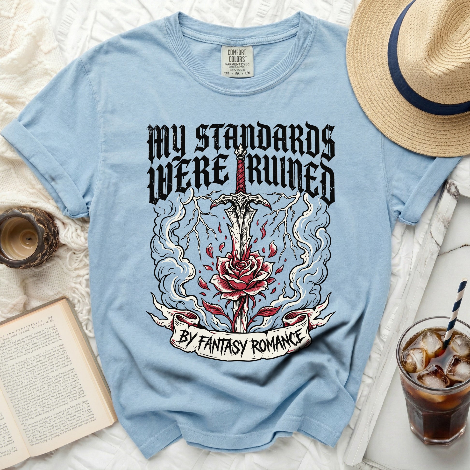 Light blue t-shirt with "My Standards Were Ruined by Fantasy Romance" text and sword graphic.
