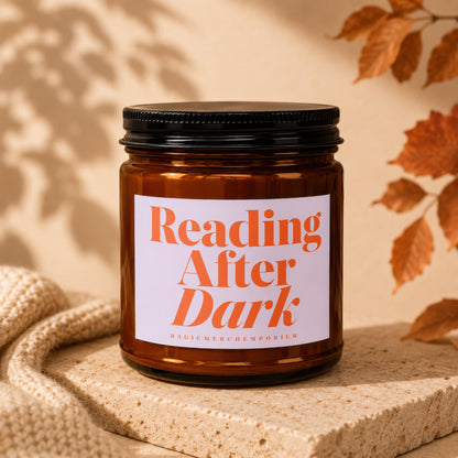 Amber glass candle with a white label reading "Reading After Dark" and "MAGICMERCH`EMPORIUM."
