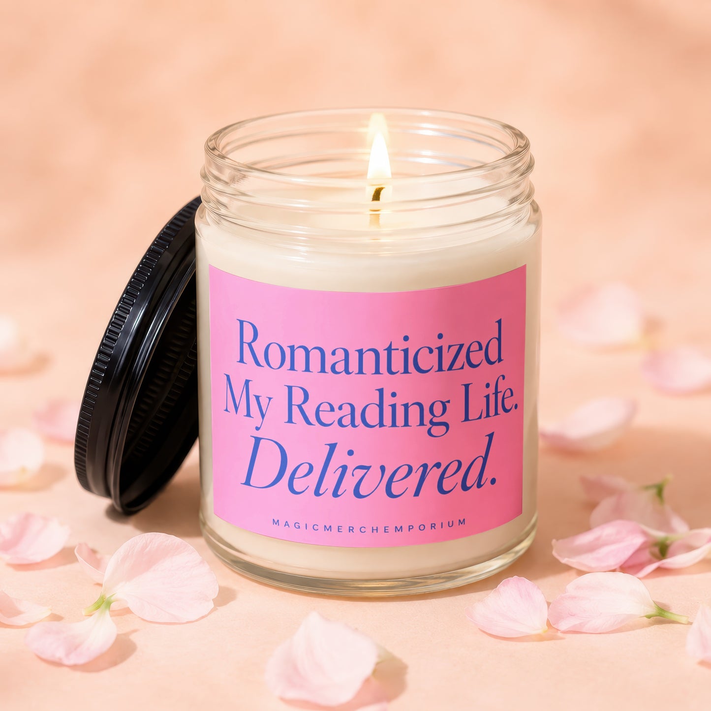 Glass candle with lit wick and pink label reading "Romanticized My Reading Life. Delivered."