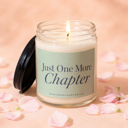 Jar candle with lit wick and "Just One More Chapter" text on label.