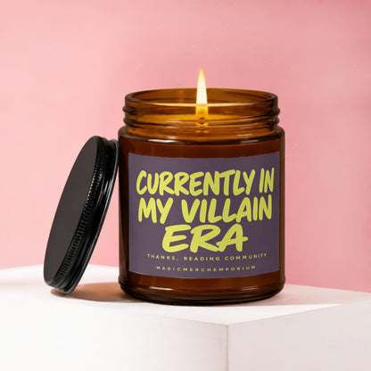 Amber jar candle with lit flame and text "Currently In My Villain Era".