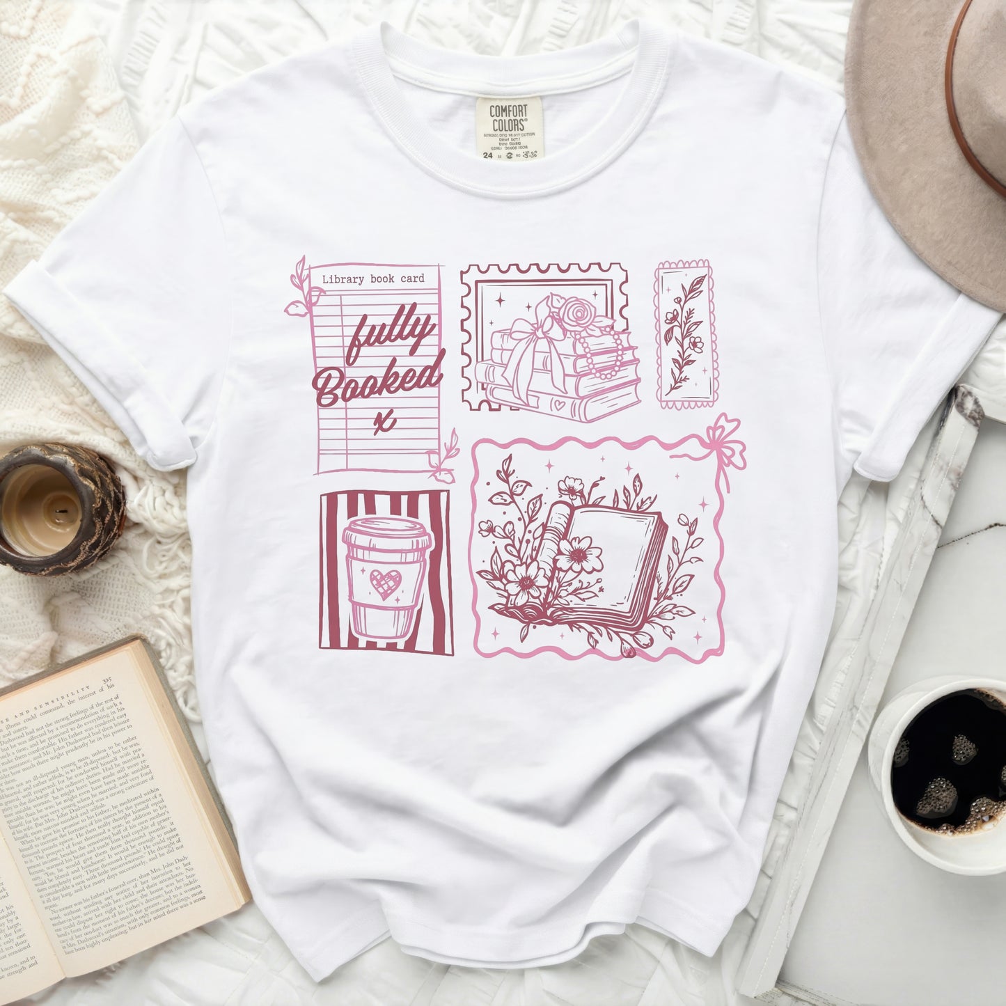 White t-shirt with pink graphic of books, coffee cup, and "fully Booked" text.