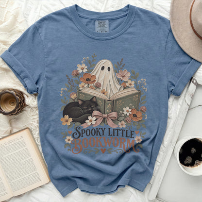 Spooky little bookworm graphic on blue t-shirt with ghost, cat, and floral design.