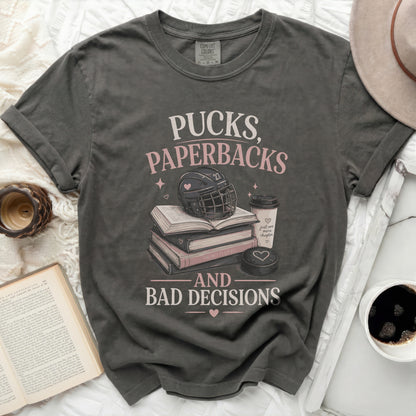 T-shirt with "Pucks, Paperbacks, and Bad Decisions" text, hockey puck, and books.