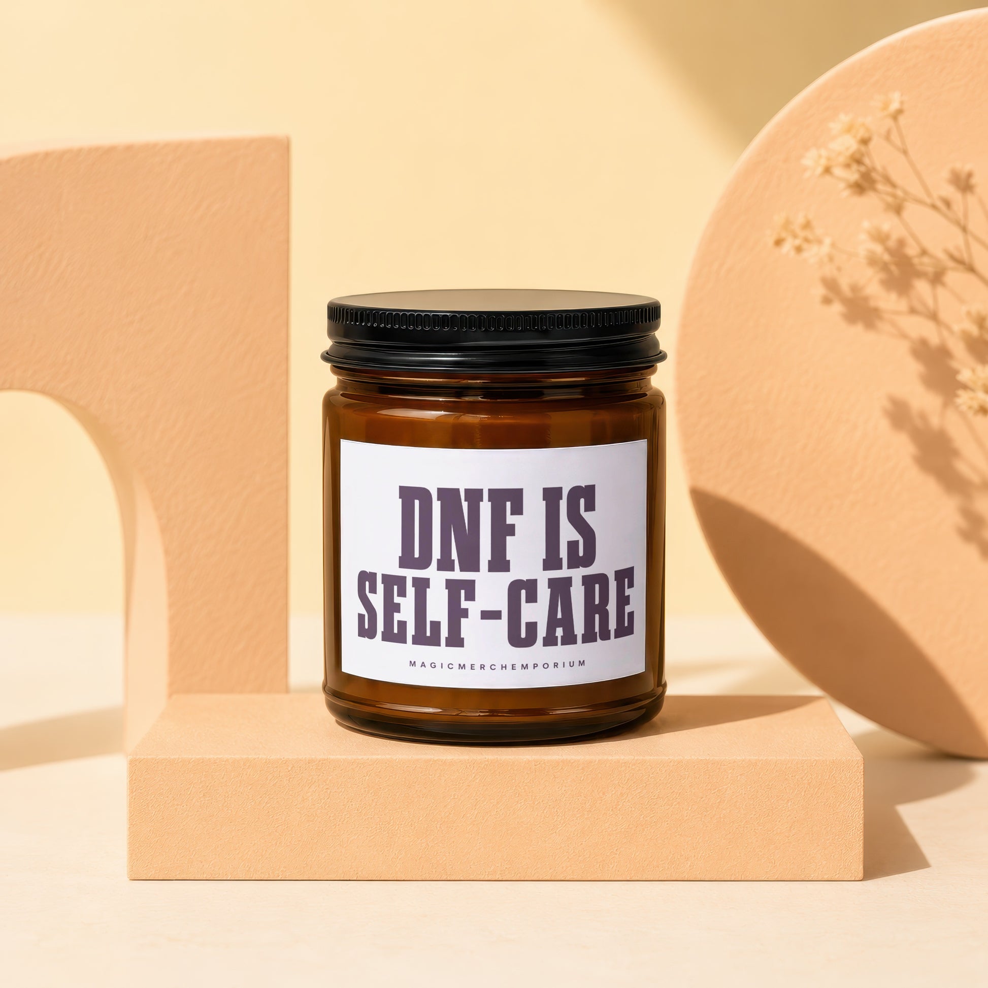 Amber jar candle with black lid reading "DNF IS SELF-CARE".