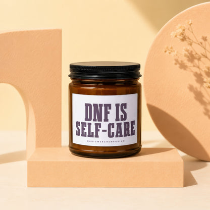 Amber jar candle with black lid reading "DNF IS SELF-CARE".